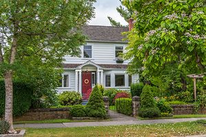 Tree company in Ocean County client home with white siding, a red door, and well maintained mature trees